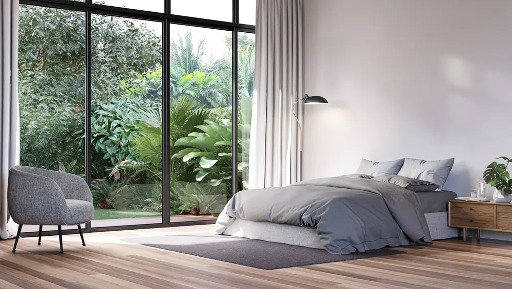 Modern bedroom with tropical style garden view 3d render,The Rooms have wooden floors ,decorate with gray fabric bed,There are large sliding doors, Overlooks wooden terrace and green garden.